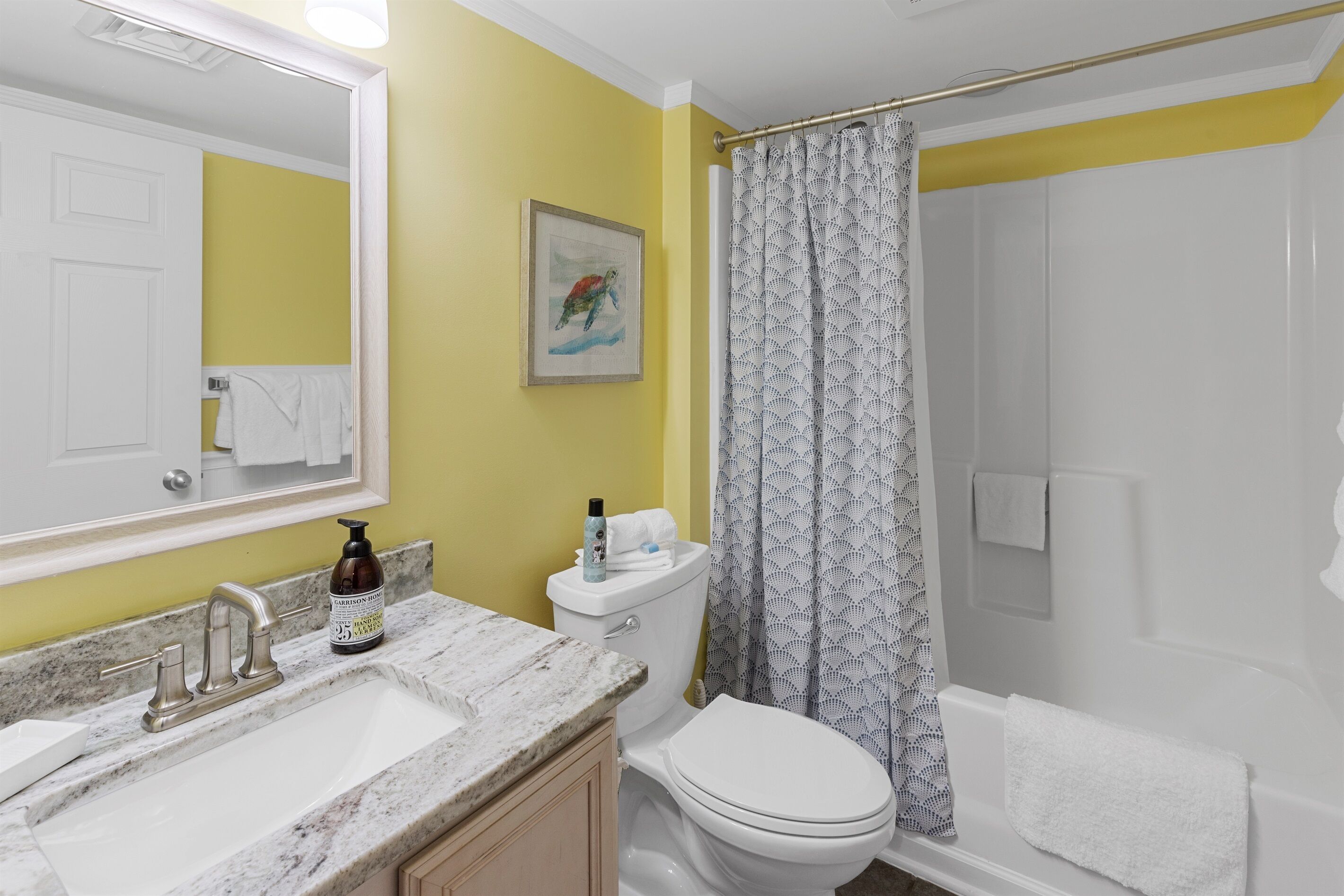 A bathroom with a sink, toilet, and shower curtain.