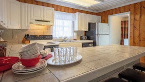 Una cucina moderna con mobili bianchi, un'isola centrale e un forno integrato.