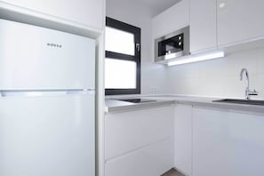 Departamento Confort, vista al jardín | Cocina privada | Refrigerador con congelador, microondas y parrilla de estufa