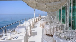 A seaside restaurant with tables set for dining, overlooking the ocean. - Linda Vista Beach Apartment (Marbella)
