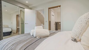 Un dormitorio con una cama, un vidrio que da al baño y una escalera.