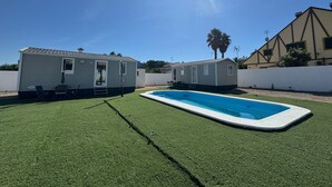Une piscine avec deux mobil-homes en arrière-plan.
