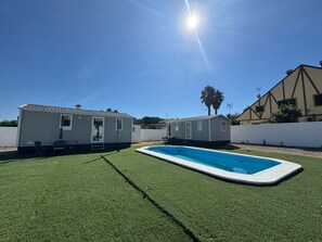 Ein Pool mit zwei Mobilheimen im Hintergrund.