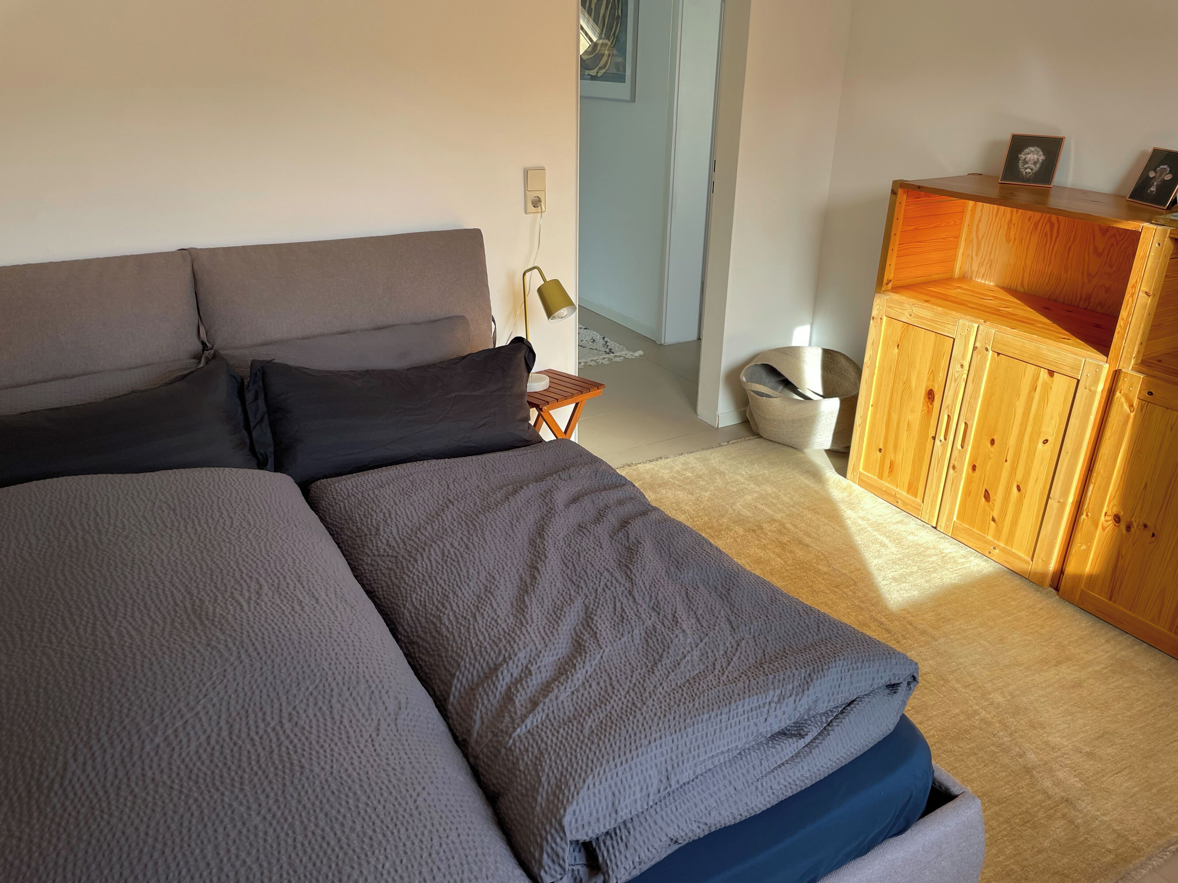Ein Schlafzimmer mit einem Bett, einem Holzschrank und einem kleinen Tisch.