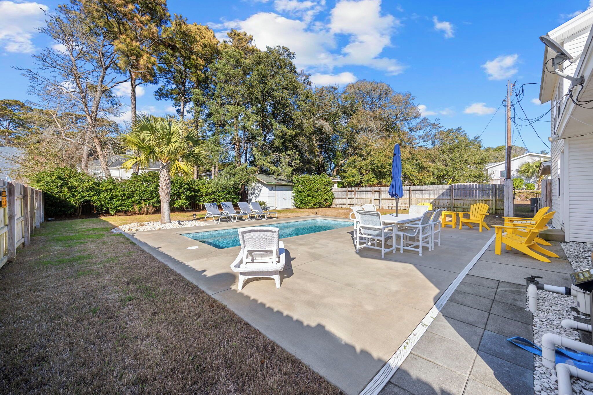 Ein Garten mit Swimmingpool, Liegestühlen und einer Terrasse.