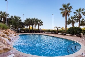 A swimming pool with a waterfall feature, surrounded by lounge chairs and palm trees. - Margate 2109 in Kingston, Oceanview, Pool, Beach (Myrtle Beach)