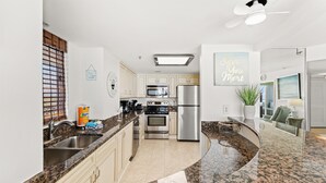 A kitchen with granite countertops, stainless steel appliances, and a ceiling fan. - N Hampton 1402 in Kingston, Oceanfront, Pool,Beach (Myrtle Beach)