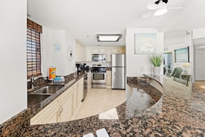 A kitchen with granite countertops, stainless steel appliances, and a ceiling fan. - Kingston N Hampton1402 Oceanview in/out pool/Beach (Myrtle Beach)