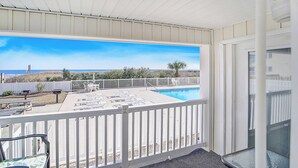A balcony with a pool, white railings, and a view of the beach. - A Place at the Beach A105 New flooring Oceanfront (Myrtle Beach)