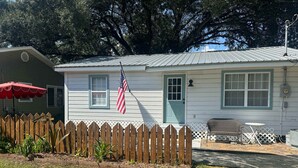 A single-story house with a front porch, a small deck, and a fenced yard. - Friendly Home Near Downtown UL - Fenced Yard (Lafayette)