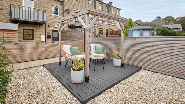 A wooden deck with outdoor furniture, a pergola, and a garden area with potted plants. - Host Stay Holmfirth Hideaway (Holmfirth)