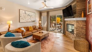 A modern living room with a sofa, coffee table, and chairs, a fireplace, and a television. - Luxury Condo - Full Spa - Steps to Keystone free shuttle!! (Keystone)