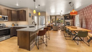 A modern kitchen with a central island, bar stools, and pendant lighting. - Luxury Condo - Full Spa - Steps to Keystone free shuttle!! (Keystone)