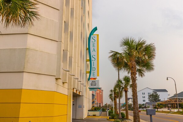 A hotel with a vertical sign reading "SEASIDE" and a welcoming message.