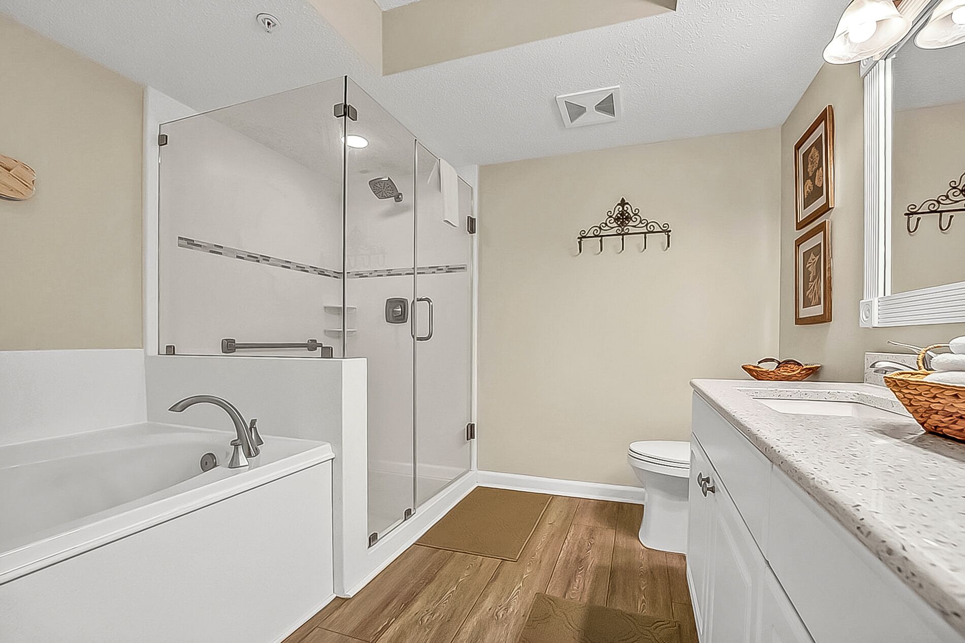 Un baño moderno con ducha acristalada, bañera independiente y tocador con lavabo y espejo.