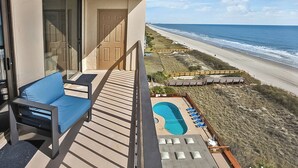 A balcony with a blue sofa and a small pool with lounge chairs. - WaterPointe II #905-Oceanfront Treasure-Pools,Gym (North Myrtle Beach)