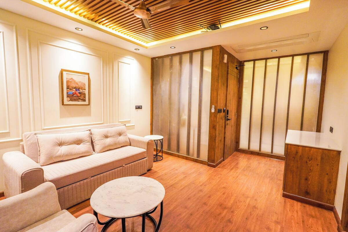 A modern living room with a sofa, a round table, and wooden flooring.