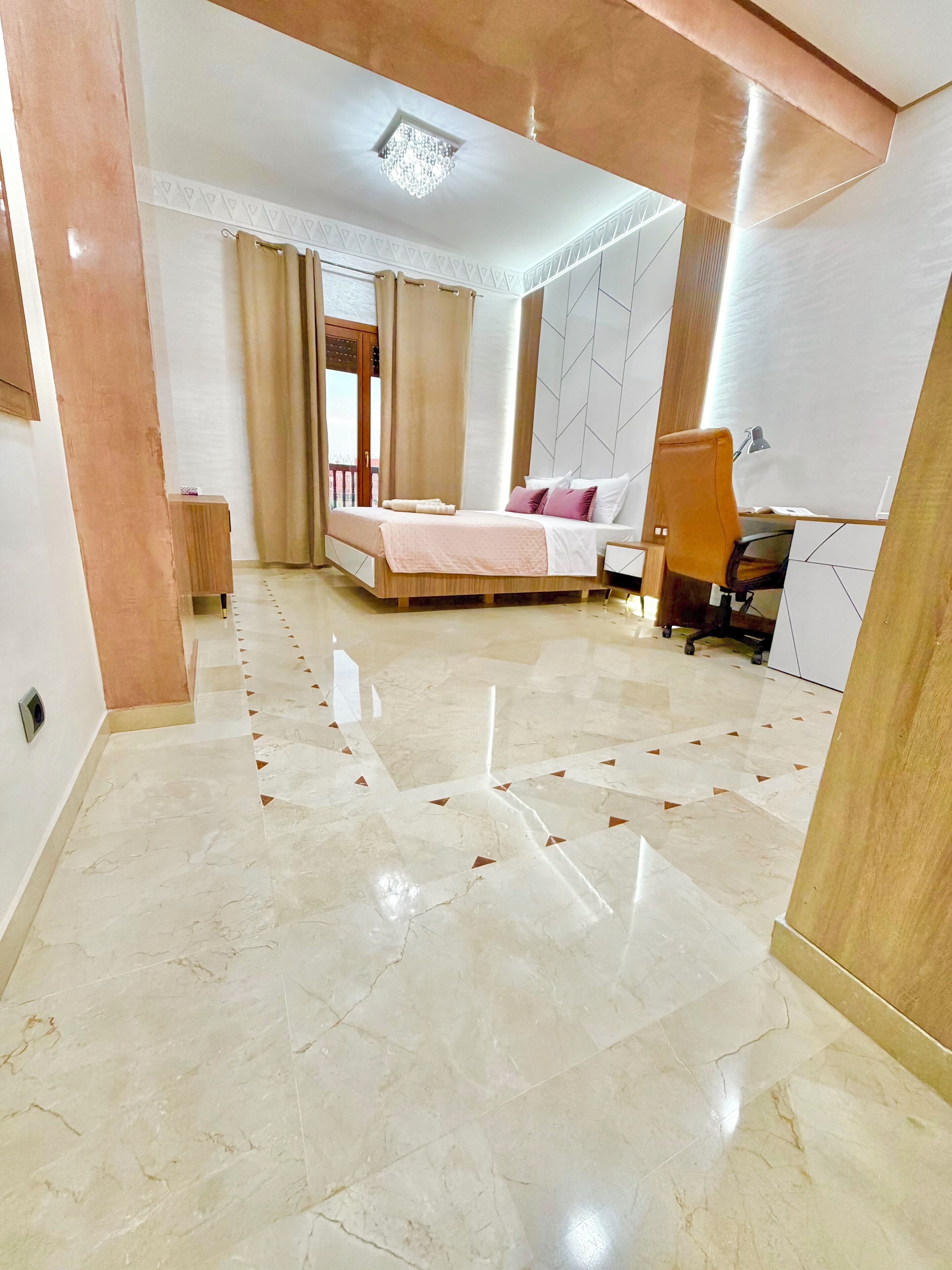 Un dormitorio moderno con una cama grande, un escritorio y una silla.