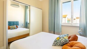 A bedroom with a bed, a mirror, a window with curtains, and a view of the outside. - Bright penthouse apartment for friends and families (Firenze)