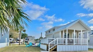 A two-story house with a covered porch and a small deck. - Vacation Cottage North Myrtle Beach (North Myrtle Beach)