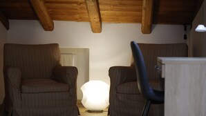 Habitació acollidora amb dues butaques amb ratlles orientades cap a una lluminària central.