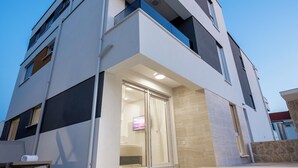 A modern multi-story building with a swimming pool in front. - Relax apartment with private pool I (Novalja)