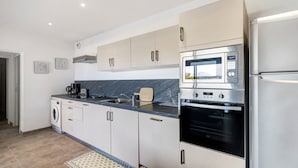 A modern kitchen with stainless steel appliances, a built-in oven, and a microwave.