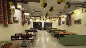 A spacious restaurant with high ceilings, multiple dining tables and booths, and ceiling fans. - Jai Hari Vilas Jodhpur (Jodhpur)