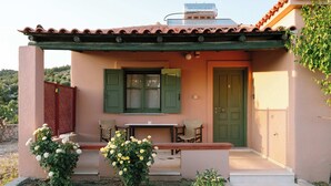 Ein Haus mit einer Veranda, einem Tisch und Stühlen.