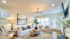 A spacious living room with a large sofa, two armchairs, a coffee table, and a chandelier. - Walk to 12 South: Getaway w/ Outdoor Dining! (Nashville)
