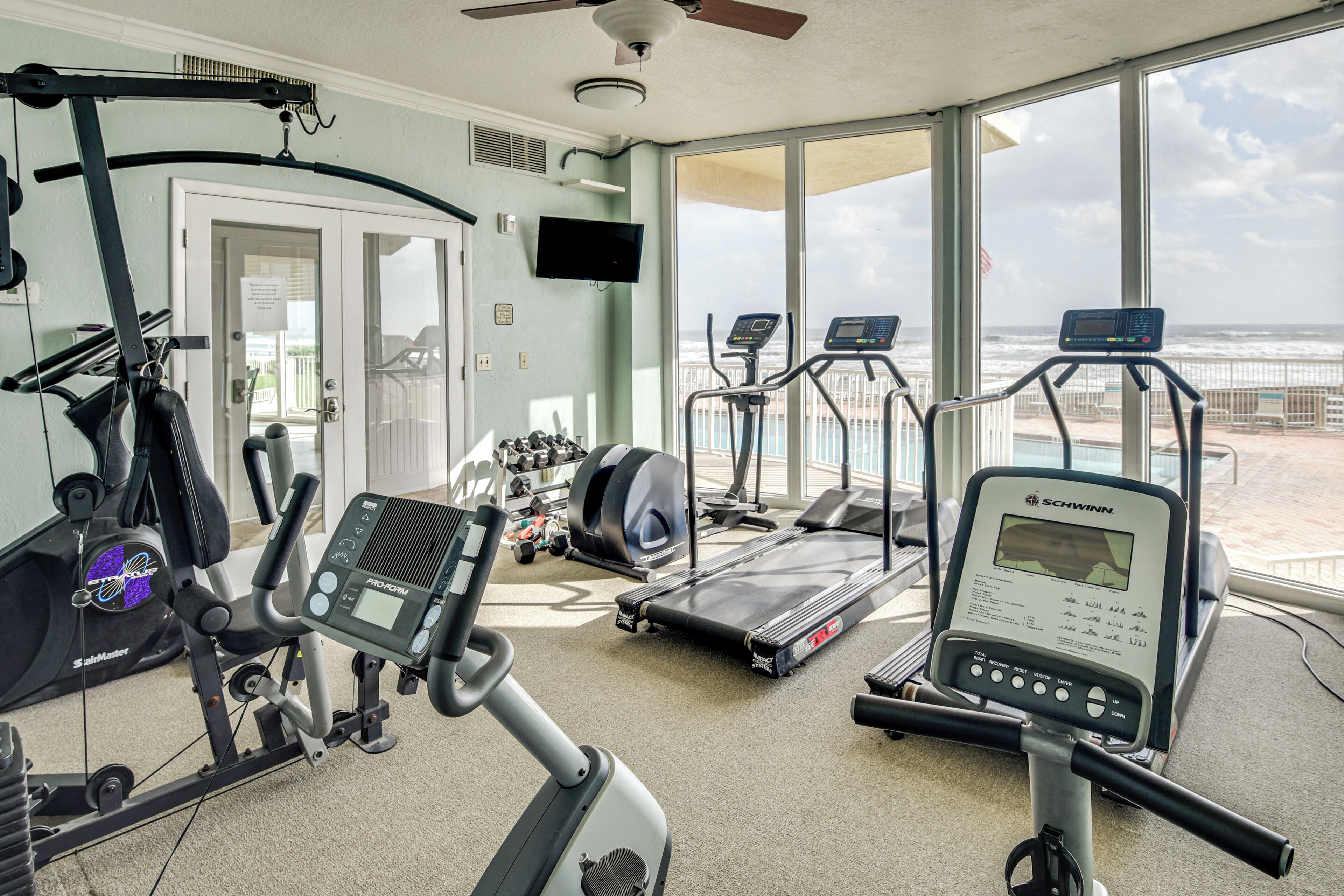 A gym with cardio machines, a treadmill, and a stationary bike.