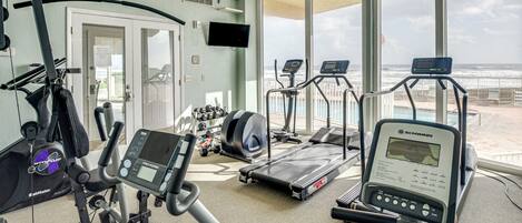 A gym with cardio machines, a treadmill, and a stationary bike.