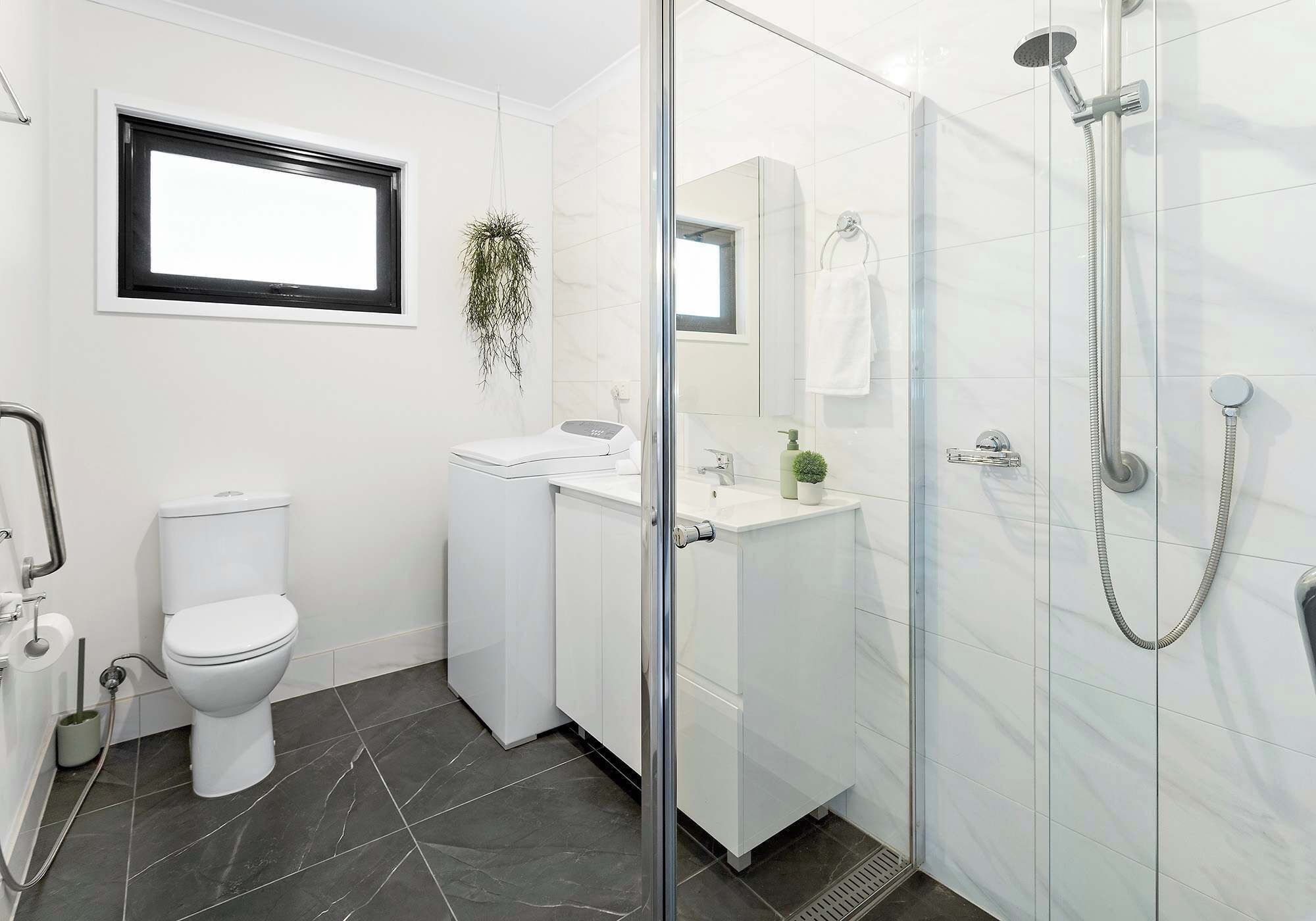 A modern bathroom with a toilet, sink, and shower.