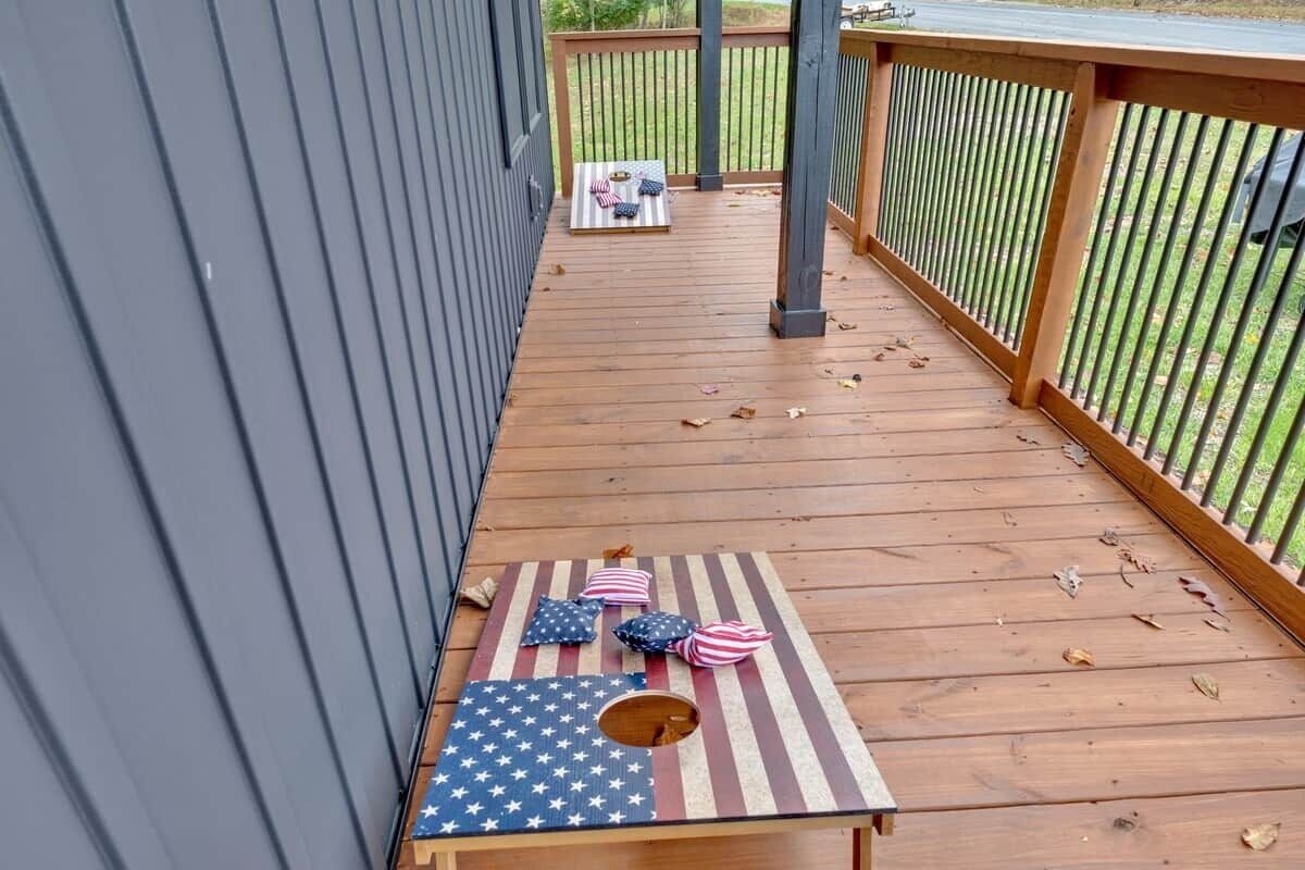 Une terrasse en bois avec une table ornée d’un motif représentant le drapeau américain, le tout entouré d’une balustrade en bois.