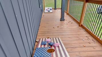 Une terrasse en bois avec une table ornée d’un motif représentant le drapeau américain, le tout entouré d’une balustrade en bois.