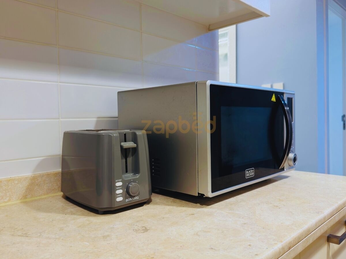 A kitchen with a toaster and a microwave on the counter.