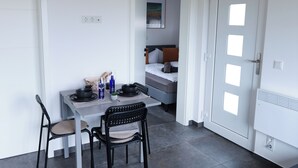 Una cocina moderna con una mesa de comedor, sillas y un televisor de pantalla plana.