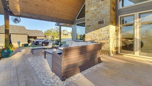 A covered patio area with a wicker sofa, a table, and a fan. - Upscale A-frame Escape w/ Lake Access in Quinton! (Eufaula)