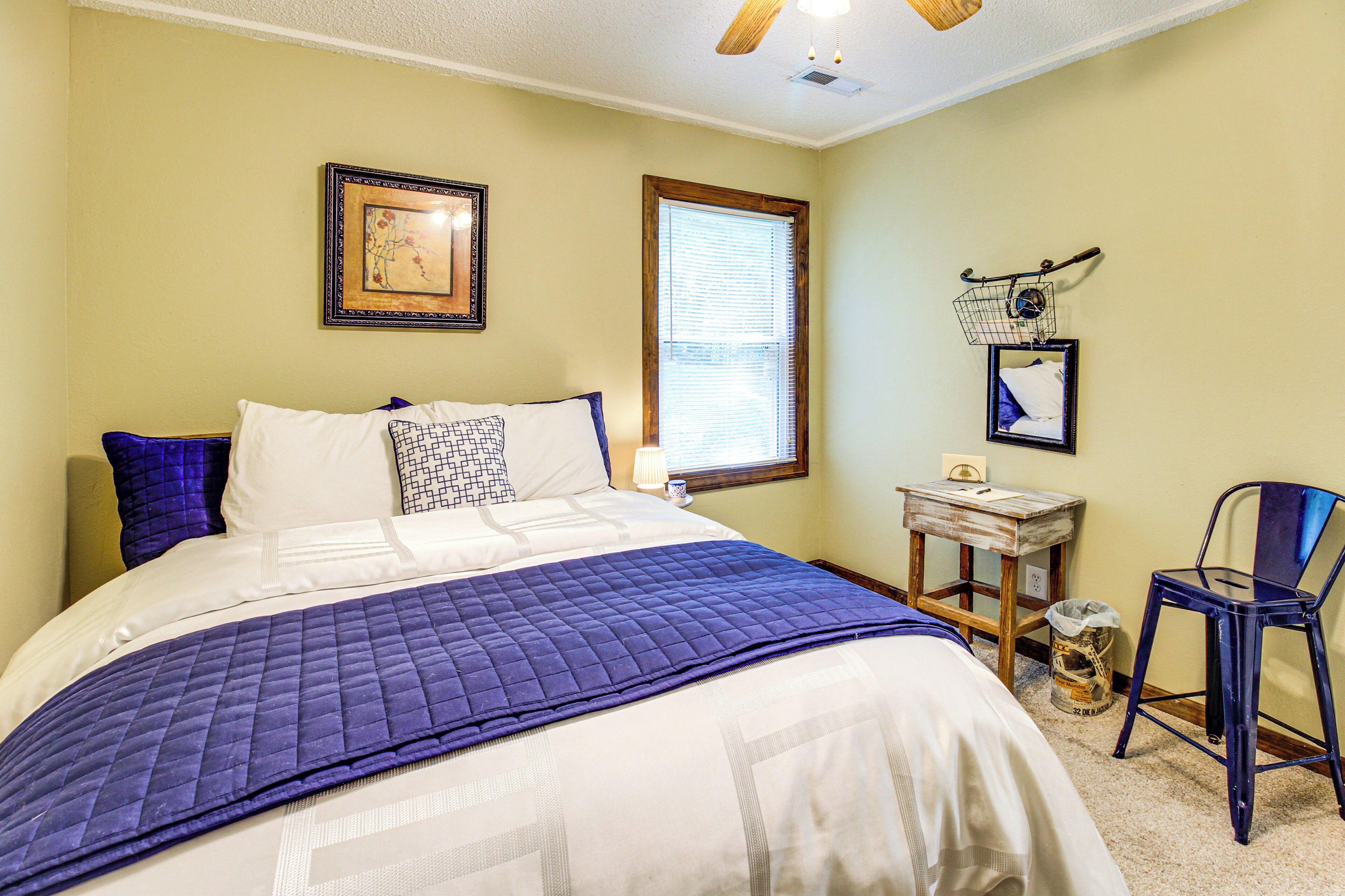 A bedroom with a bed, a window, a chair, and a small table.