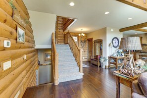 A log cabin interior with a wooden staircase, a dining area, and a kitchen. - Furnished Decks & Game Room: Sturgis Rally Cabin (Sturgis)