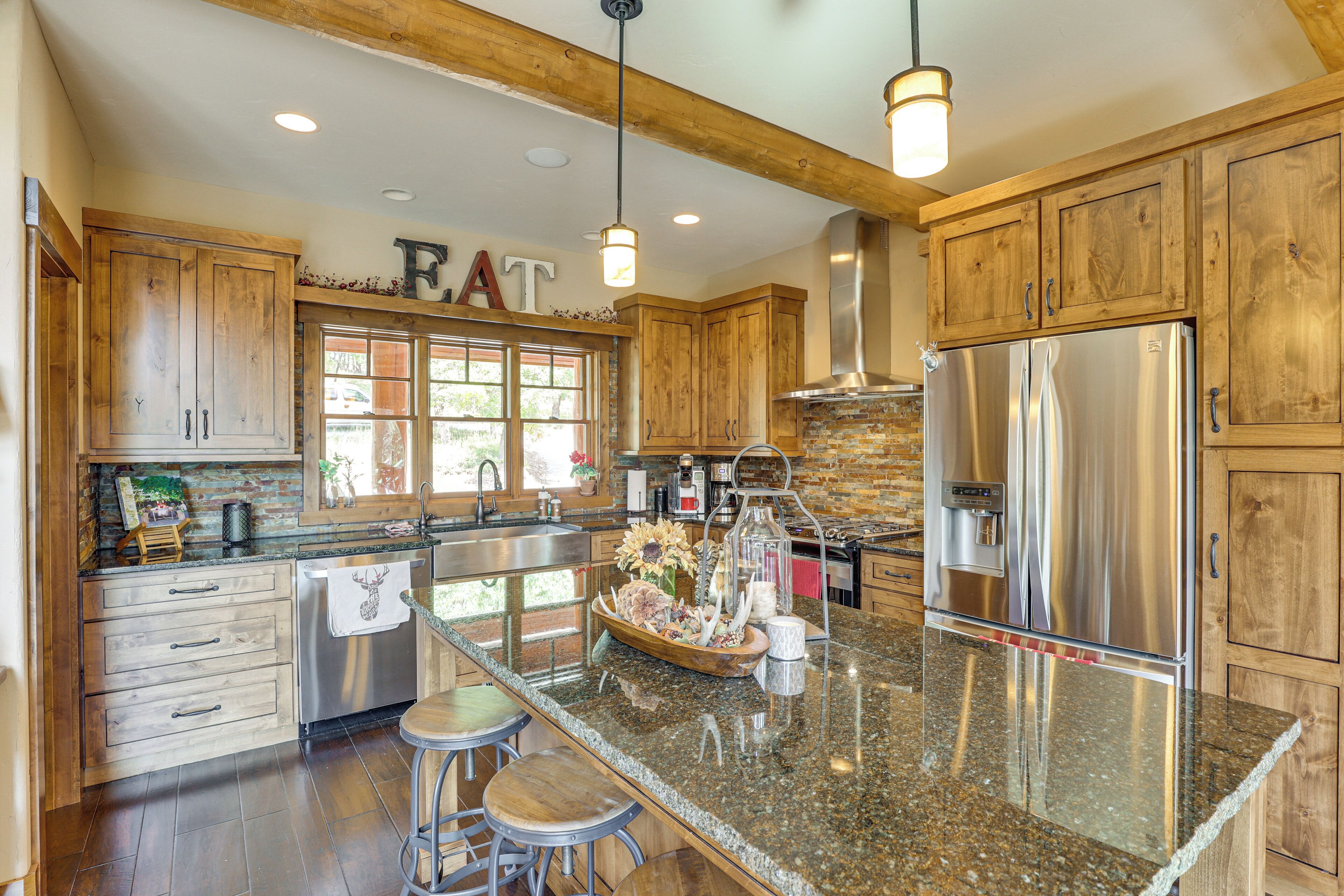 A spacious kitchen with wooden cabinets, stainless steel appliances, and a granite countertop.