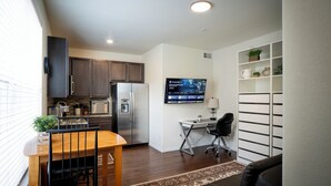 A compact living space with a kitchen, dining area, and a small office setup.