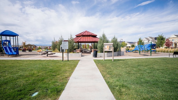 A park with a red pavilion, picnic tables, and playground equipment.