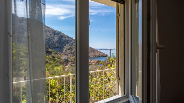 A balcony with a view of a mountainous landscape and a body of water.