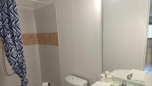 A bathroom with a shower, toilet, sink, and mirror. - Le bistrot du berger (Le Vernet)