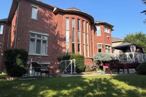A red brick building with a curved facade, a covered outdoor seating area, and a small garden. - Ru U Art (Richmond Hill)