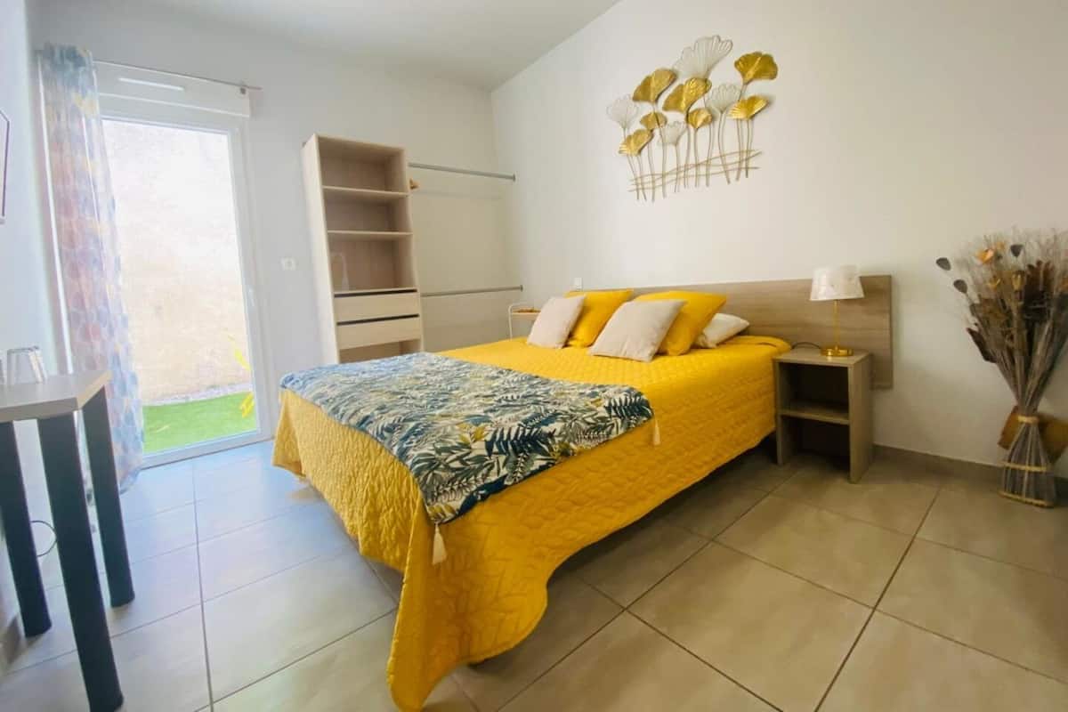 A bedroom with a bed, bedside table, and a wall decoration.