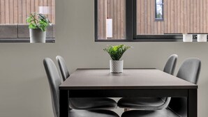 Un espace repas moderne avec une table, des chaises et des plantes en pot.