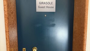 A dark blue door with a sign reading 'GIRASOLE Guest House'.