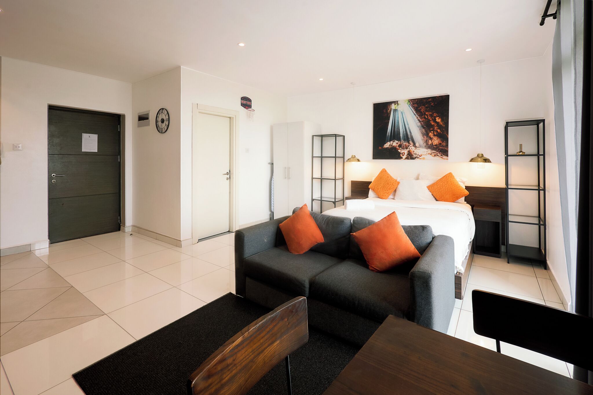 Une chambre d’hôtel moderne, équipée d’un lit, d’un canapé, d’un bureau et d’un tableau au mur.